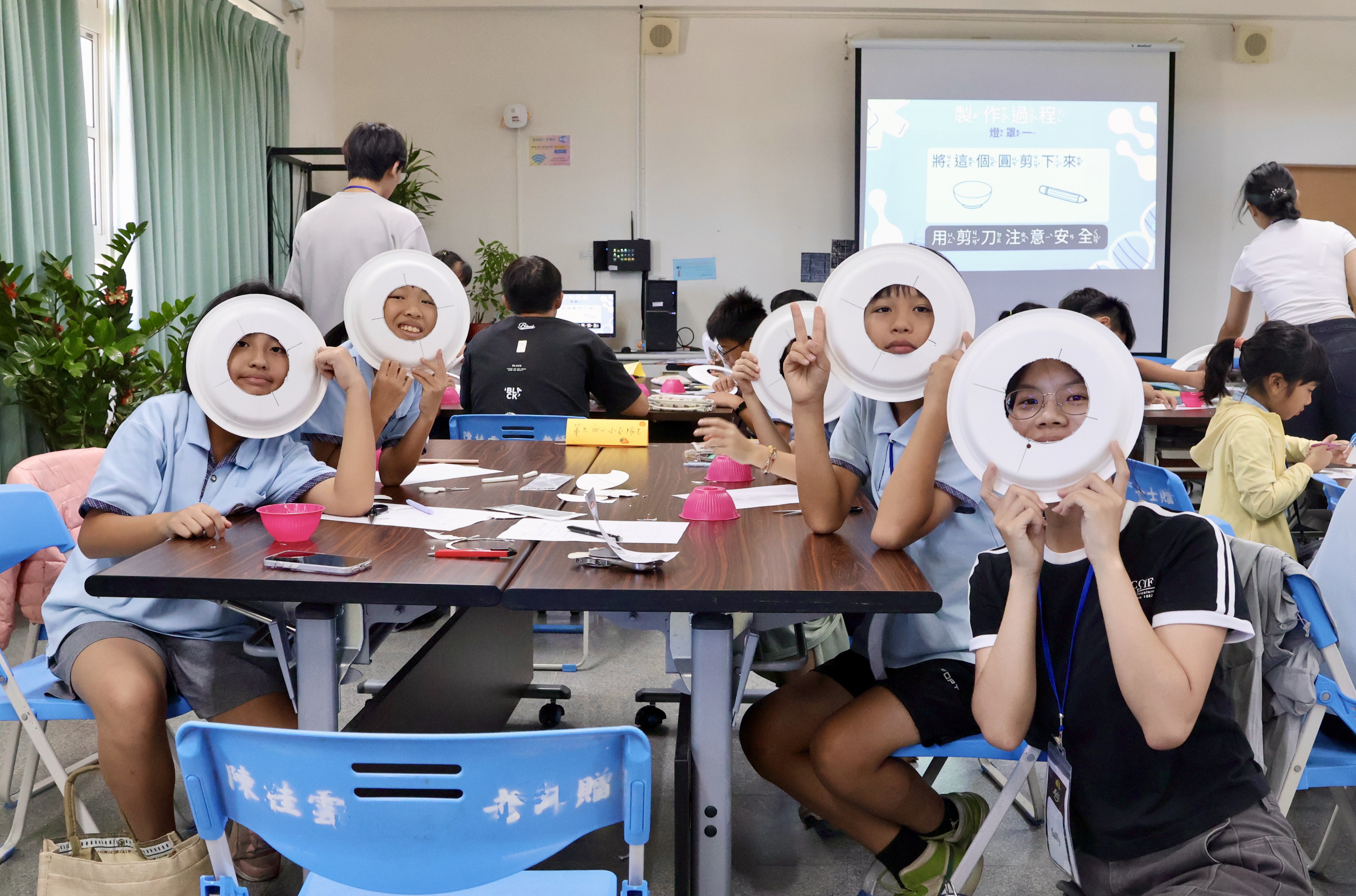 孩子們展示親手製作的燈罩，將「把光線留在地面」的想法化為具體行動。